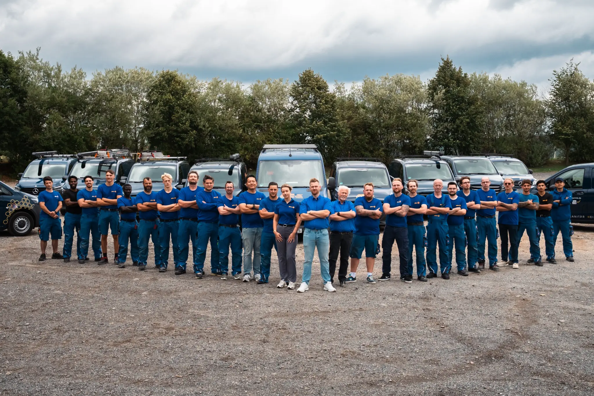 Das Möller-Team vor dem Firmenfuhrpark