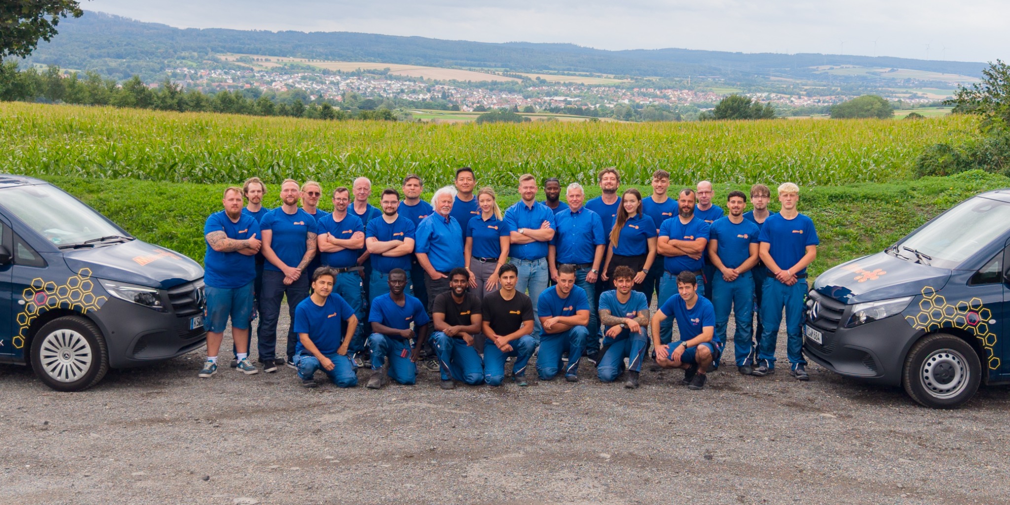 Das Team von Möller Gebäudetechnik vor den Firmenfahrzeugen